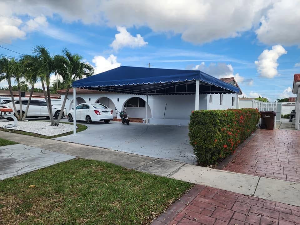 Blue carport canopy shading a residential driveway
