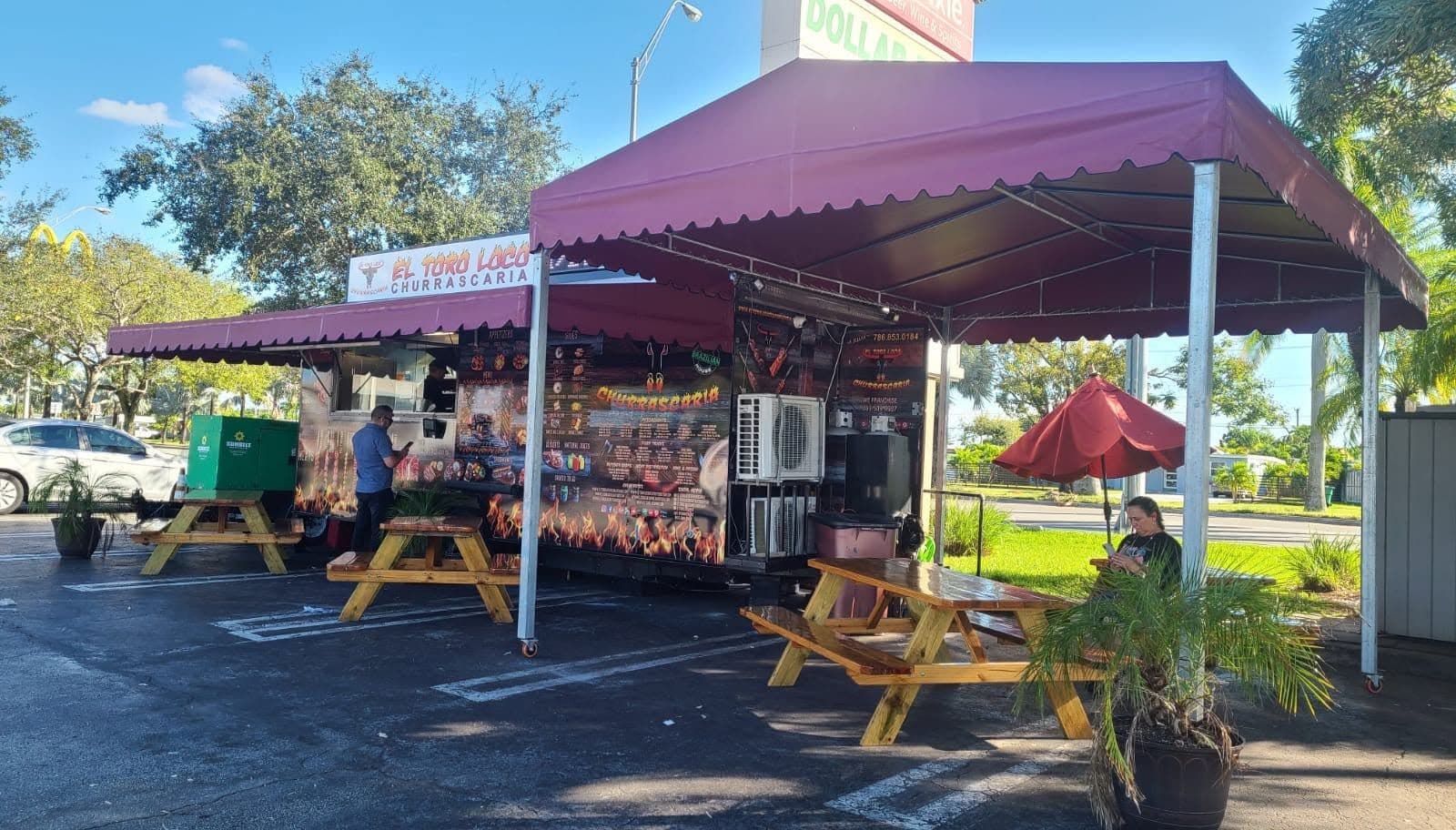 Burgundy awnings shading picnic tables at an outdoor restaurant